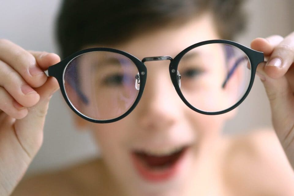 Modern eyeglasses being held up showing clear vision correction