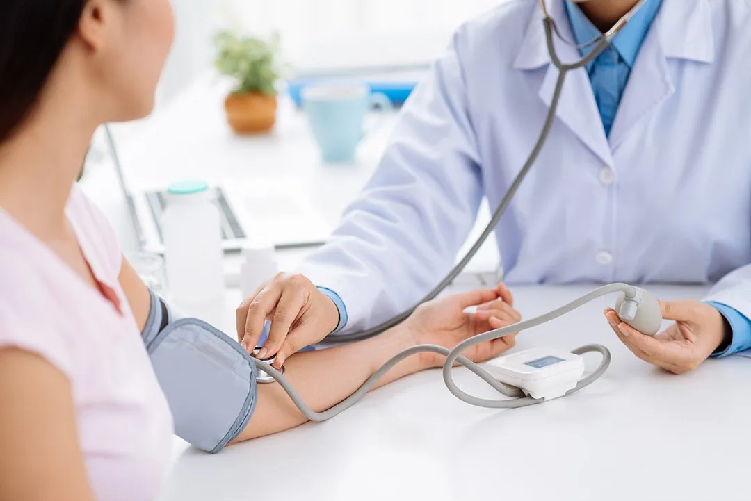 Doctor taking patient's blood pressure during comprehensive health checkup